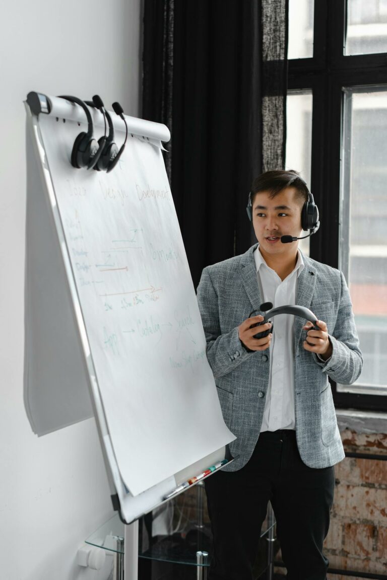 Asian man with headset explains on a flipchart during a virtual meeting. Ideal for business and communication themes.